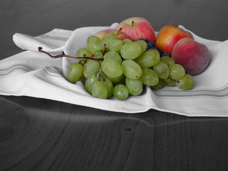 Foto di frutta colorata su sfondo in bianco e nero