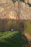Bank of Lago di Porta with bikers and wall of quarry